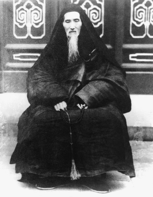 An old black and white picture of Shaolin Hsu Yun (Great Grandmaster Gao Jhi Fut Sao) at Guang YJ Monastery Beijing 1952, sitting down with a long white beard hanging from his chin 6 or 8 inches long.